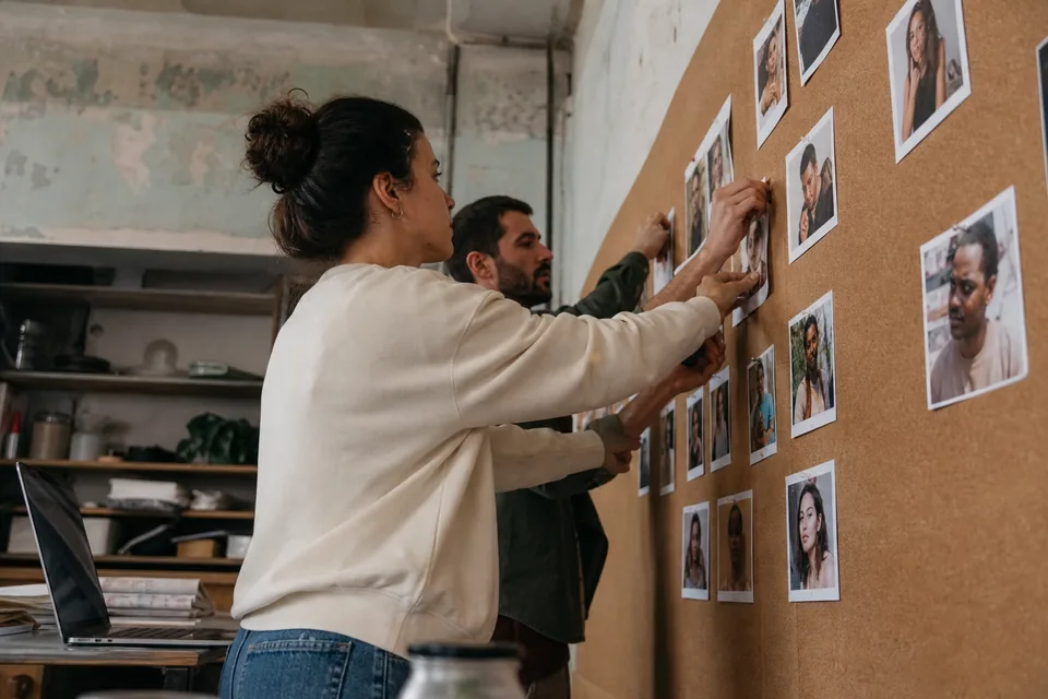 Marketers sorting printed creator profile cards on a board by niche